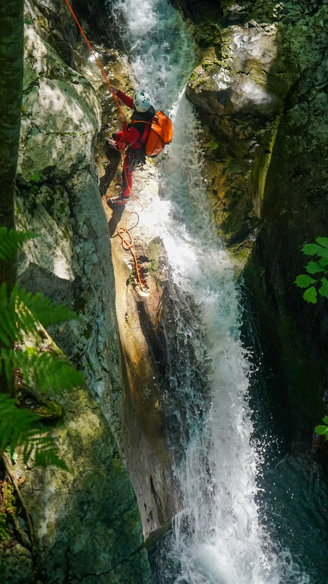 Advanced canyoning in Kozjak Gorge with a participant rappelling beside a waterfall