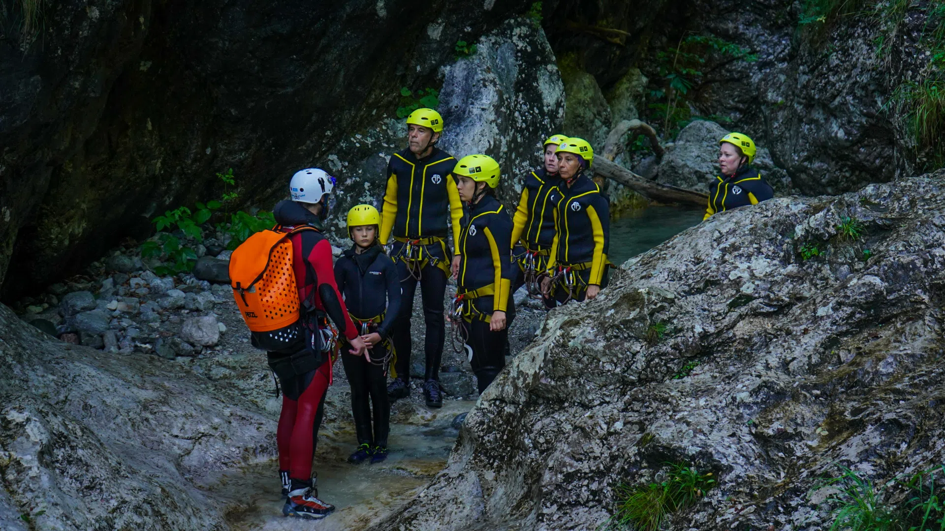 Beginner canyoning group moving through a rocky gorge