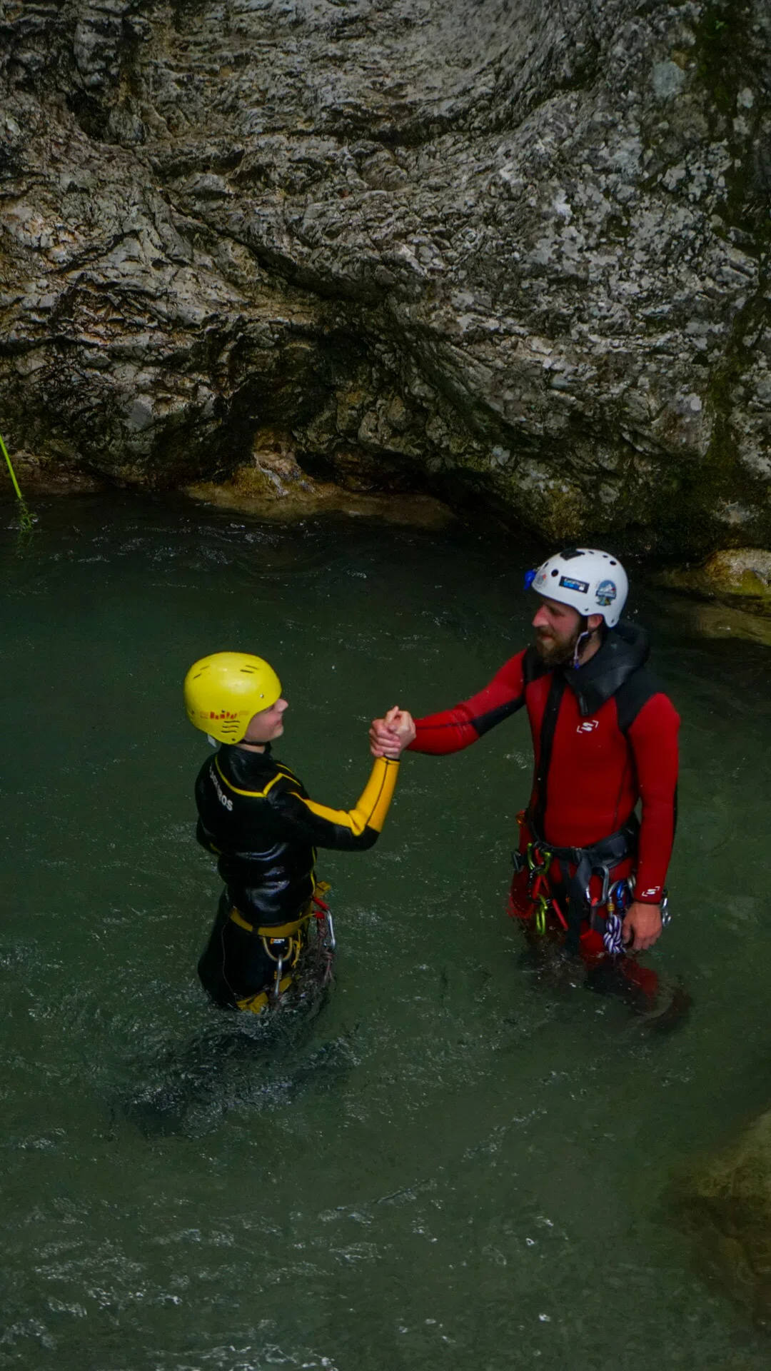Canyoning guide helping a guest in a canyon pool