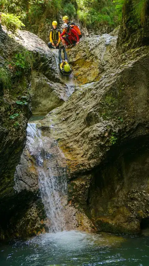 Participant descending a natural water slide in the canyon