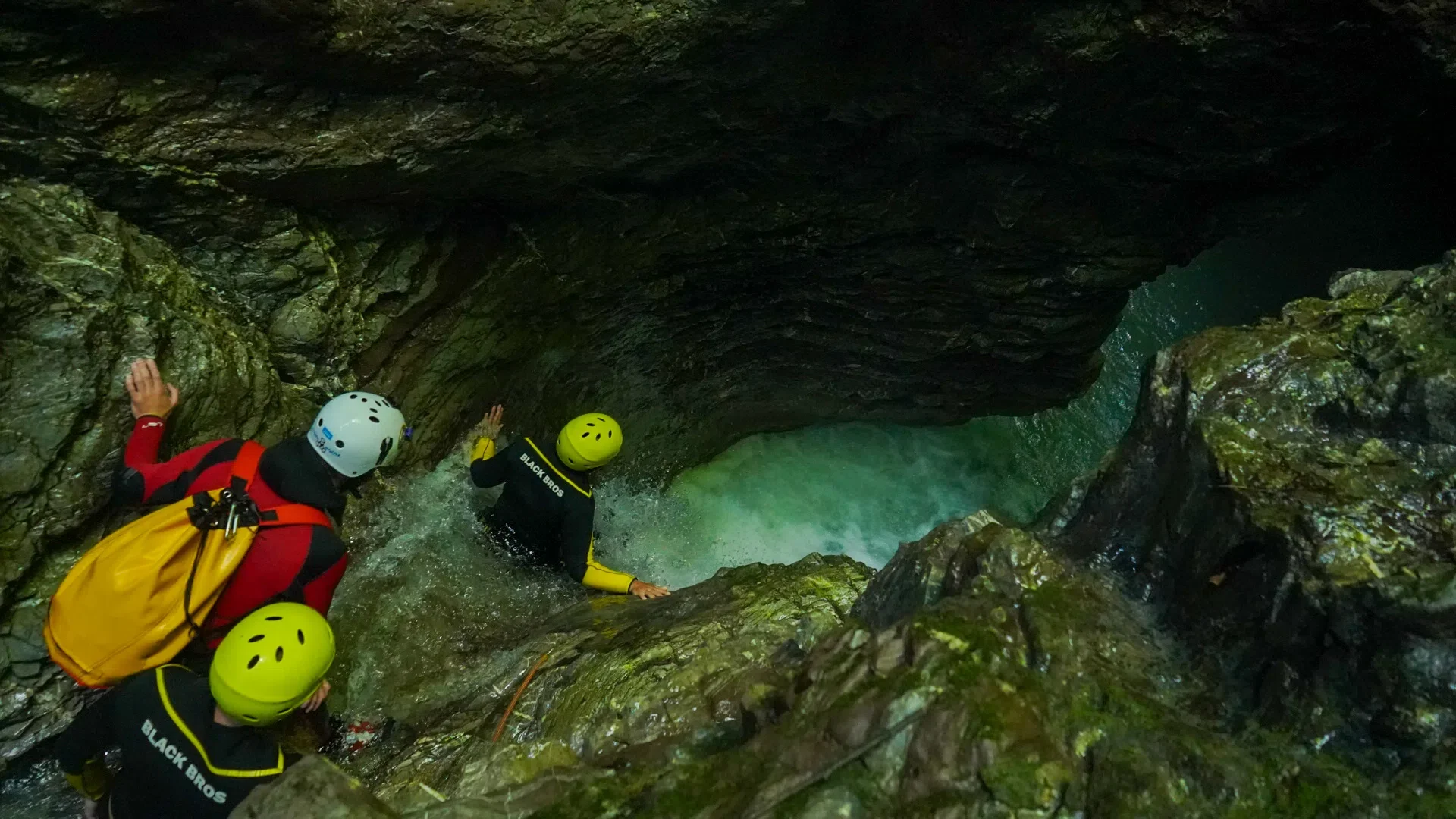 Canyoning group moving through a narrow water-filled gorge near Kobarid in the Soča Valley.