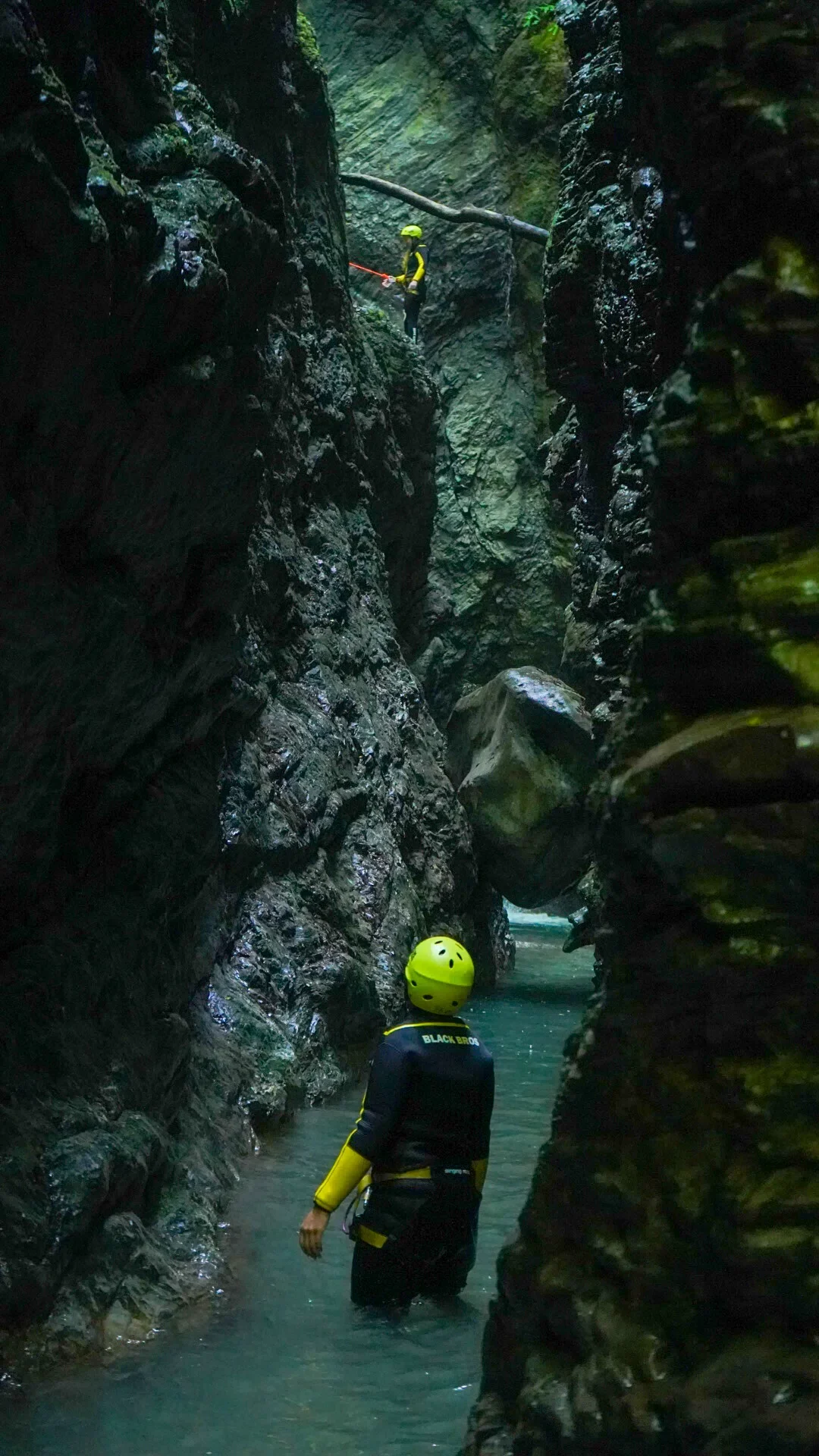 Canyoning participant descending through a narrow rocky gorge near Kobarid.