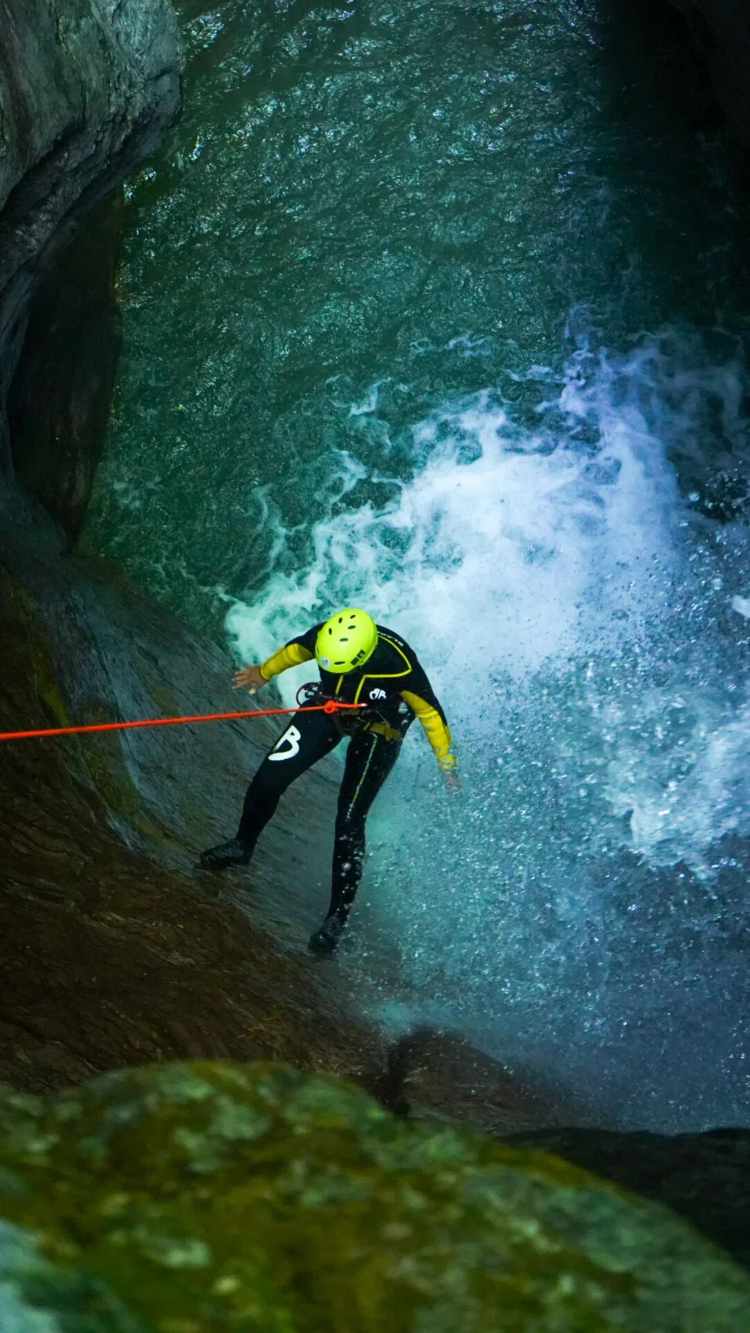 Advanced canyoning participant rappelling into a clear blue pool in a gorge near Kobarid.