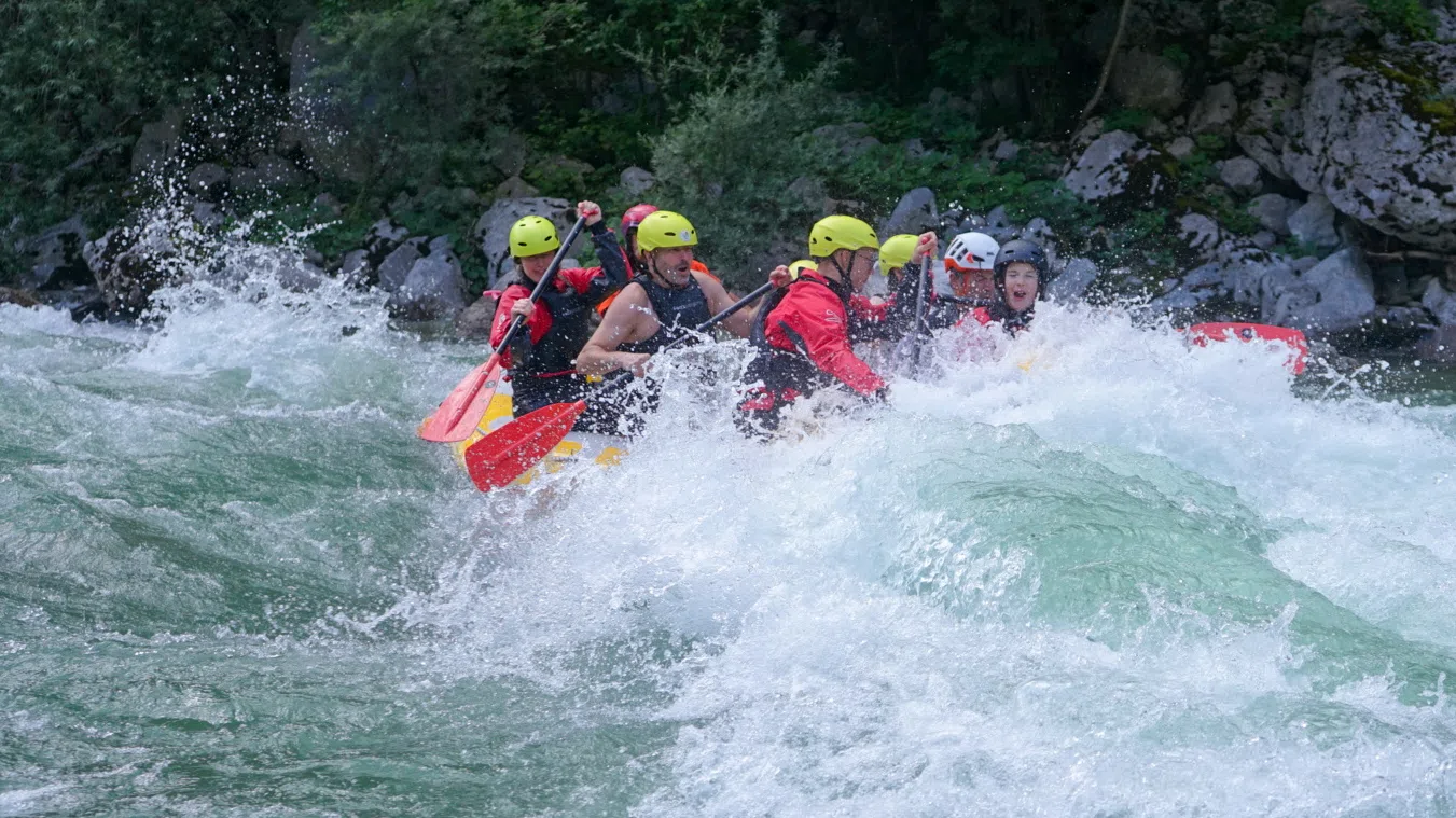 Rafting group paddling through whitewater on the Soča River