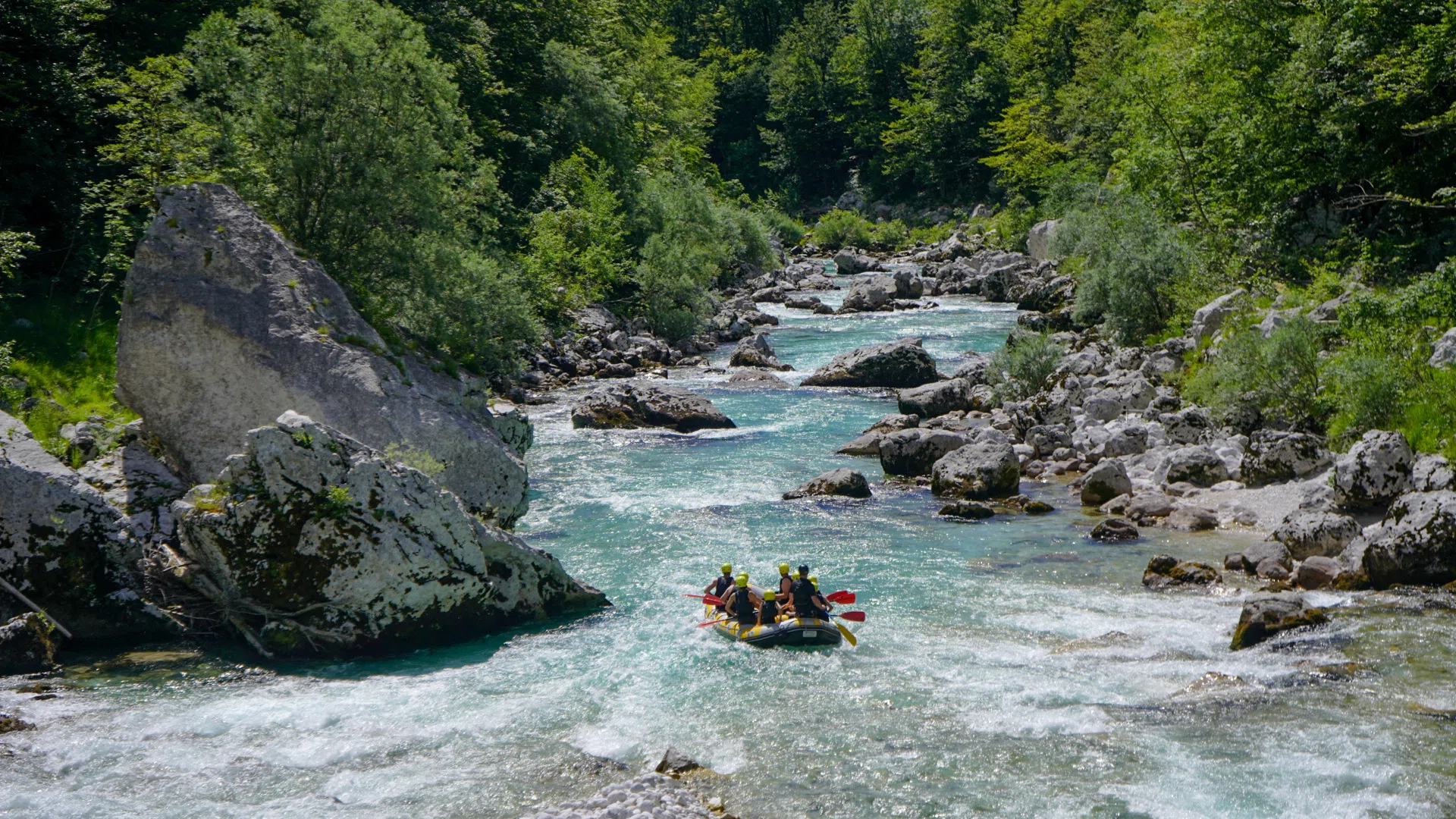 Rafting group posing together beside the Soča River