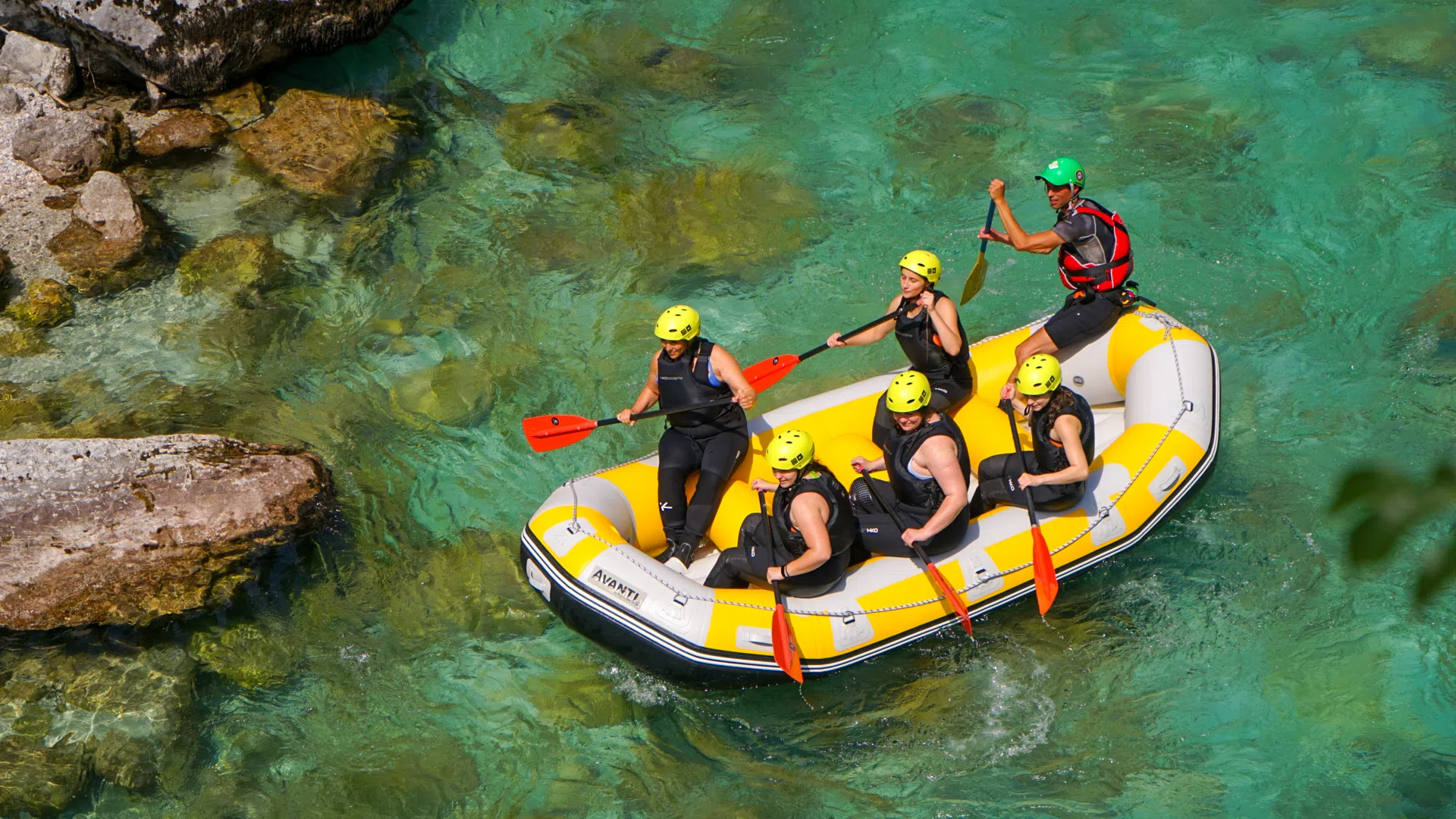 Side view of a rafting group paddling through moving water