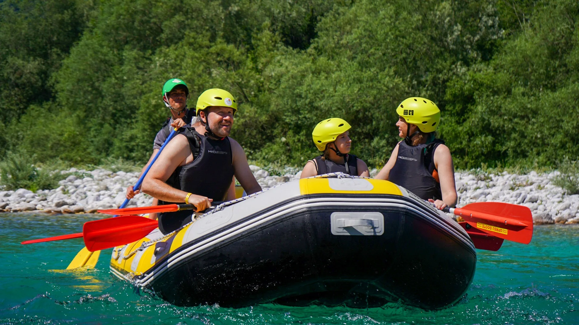 Family enjoying a relaxed rafting trip on the Soča River in the Soča Valley