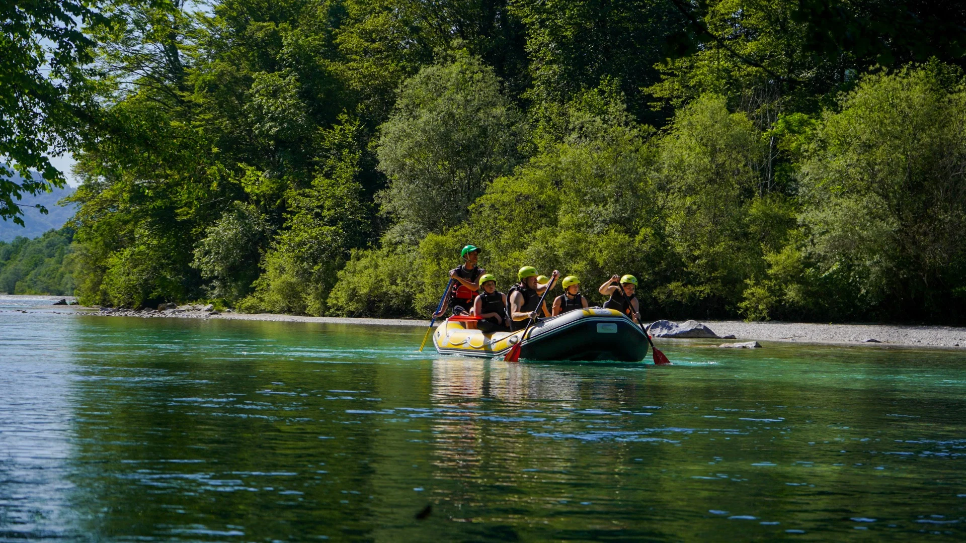 Relaxed rafting group enjoying the calm turquoise Soča River near Kobarid, Slovenia