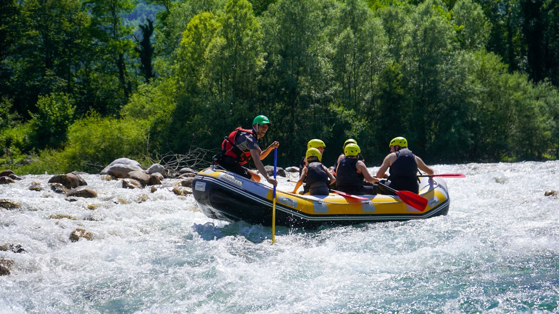 Relaxed rafting group paddling through gentle rapids on the Soča River